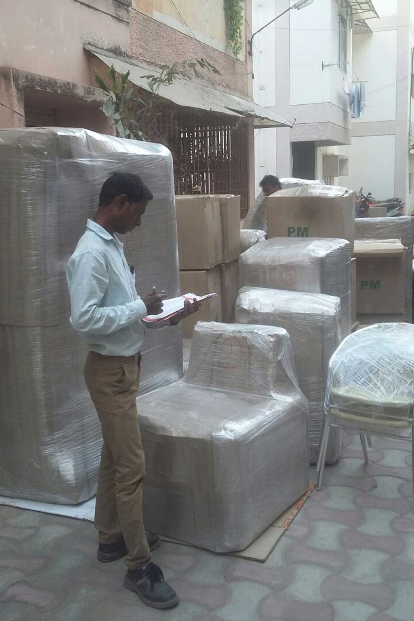 Alto Packers staff taking inventory of wrapped furniture and cartons