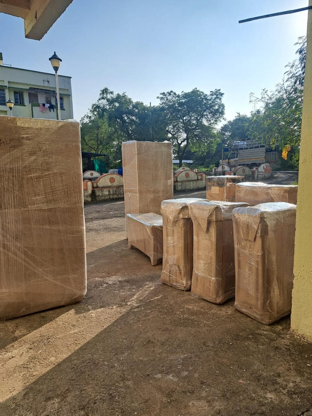 Packed furniture staged for loading by Aman Packers and Movers