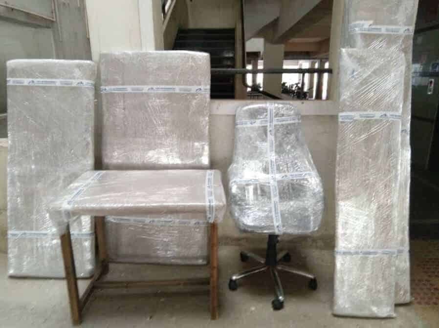 Office chair and furniture wrapped in branded packing film staged in a stairwell