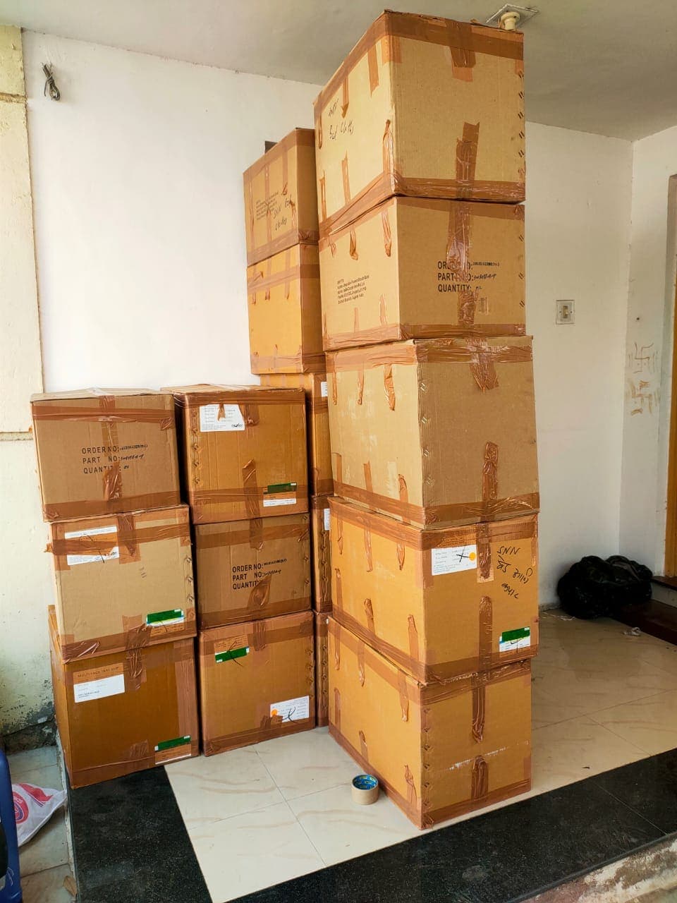 Wrapped furniture and boxes marked by room, including a labelled round table