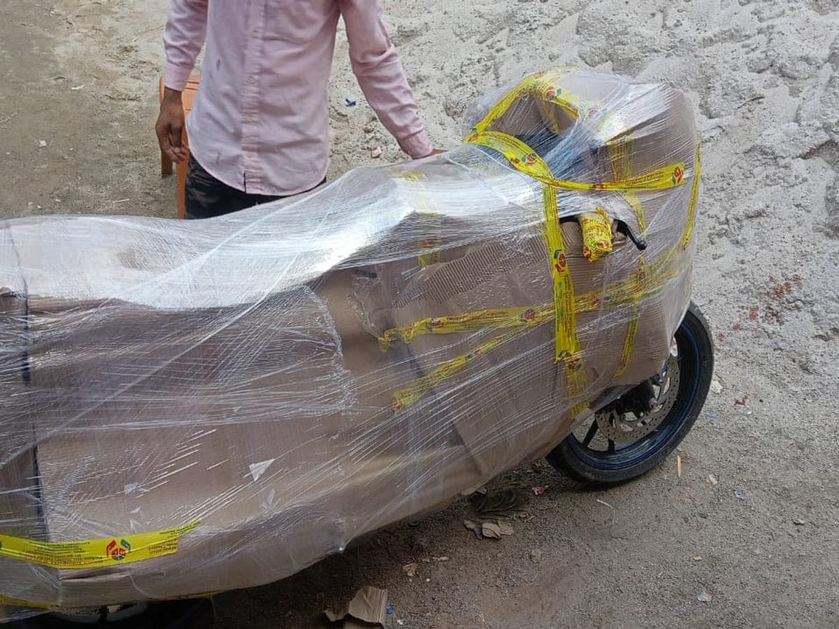 A motorcycle boxed in corrugated sheet and wrapped in stretch film with branded tape