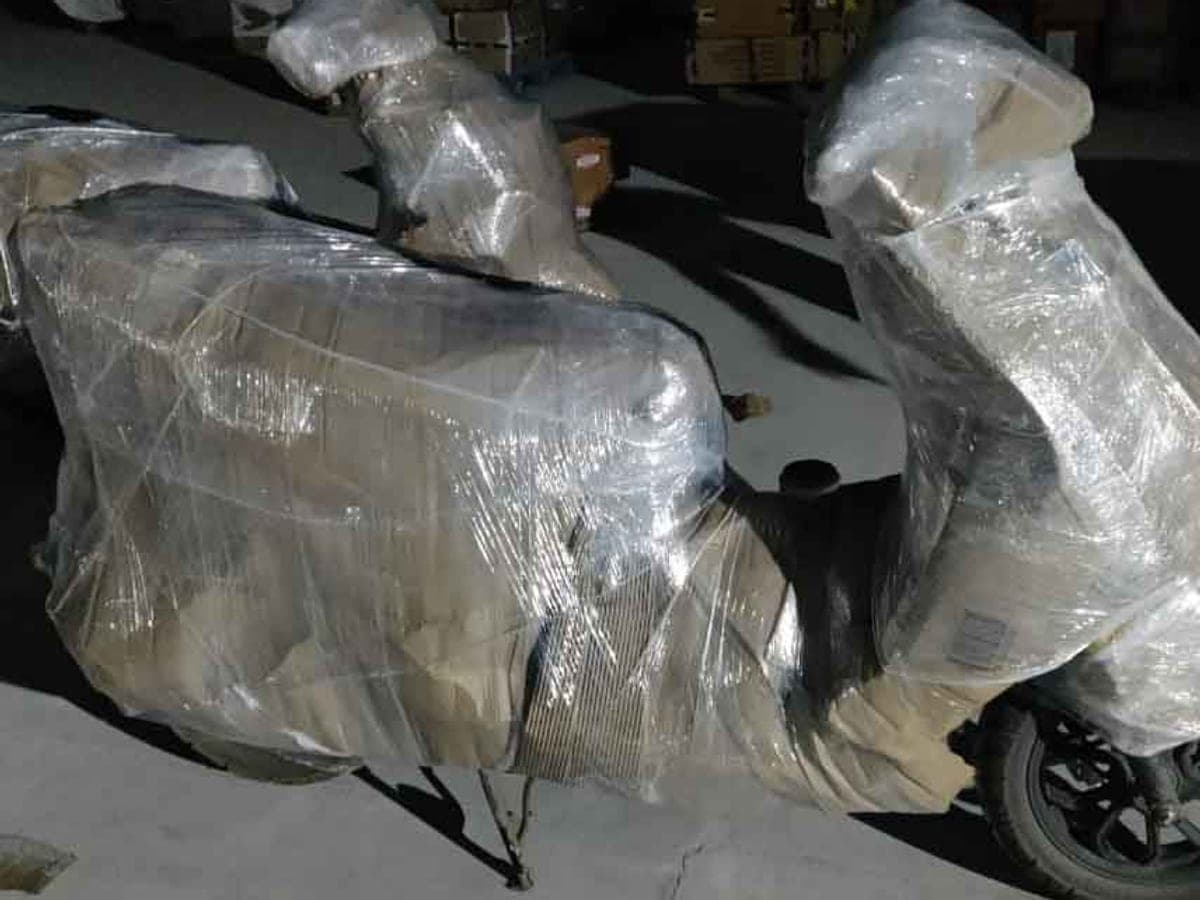 A scooter wrapped in layers of stretch film and corrugated sheet in a warehouse