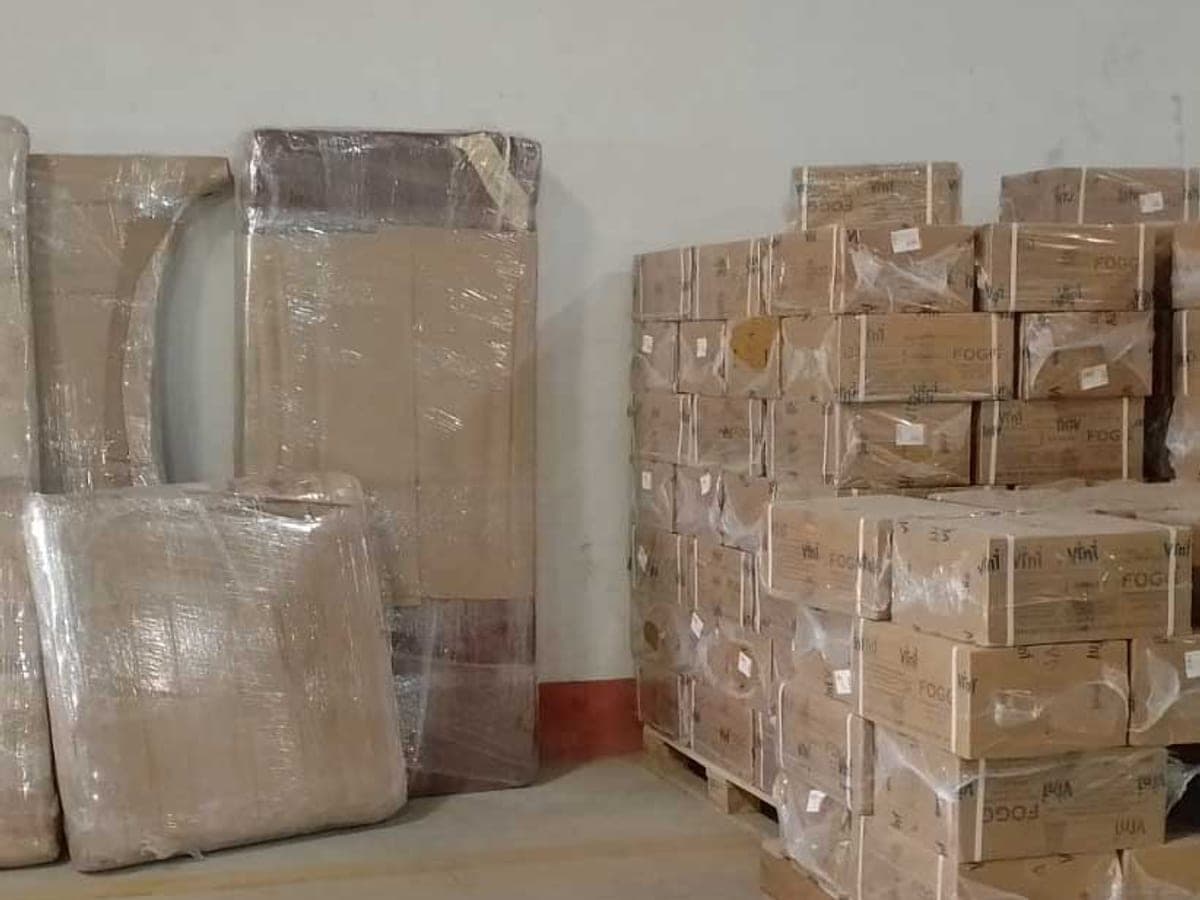 Wrapped furniture panels and stacked cartons staged against a wall before loading