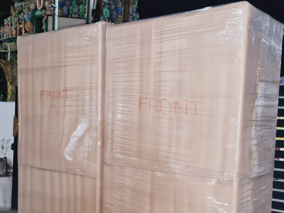 Two large wardrobe-sized boxes wrapped in film and marked FRONT