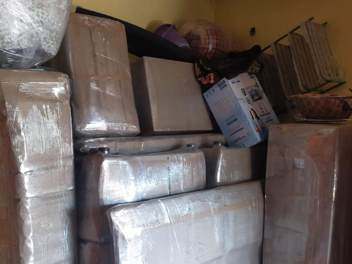 The inside of a loaded moving truck packed with wrapped cartons, mattresses and household goods