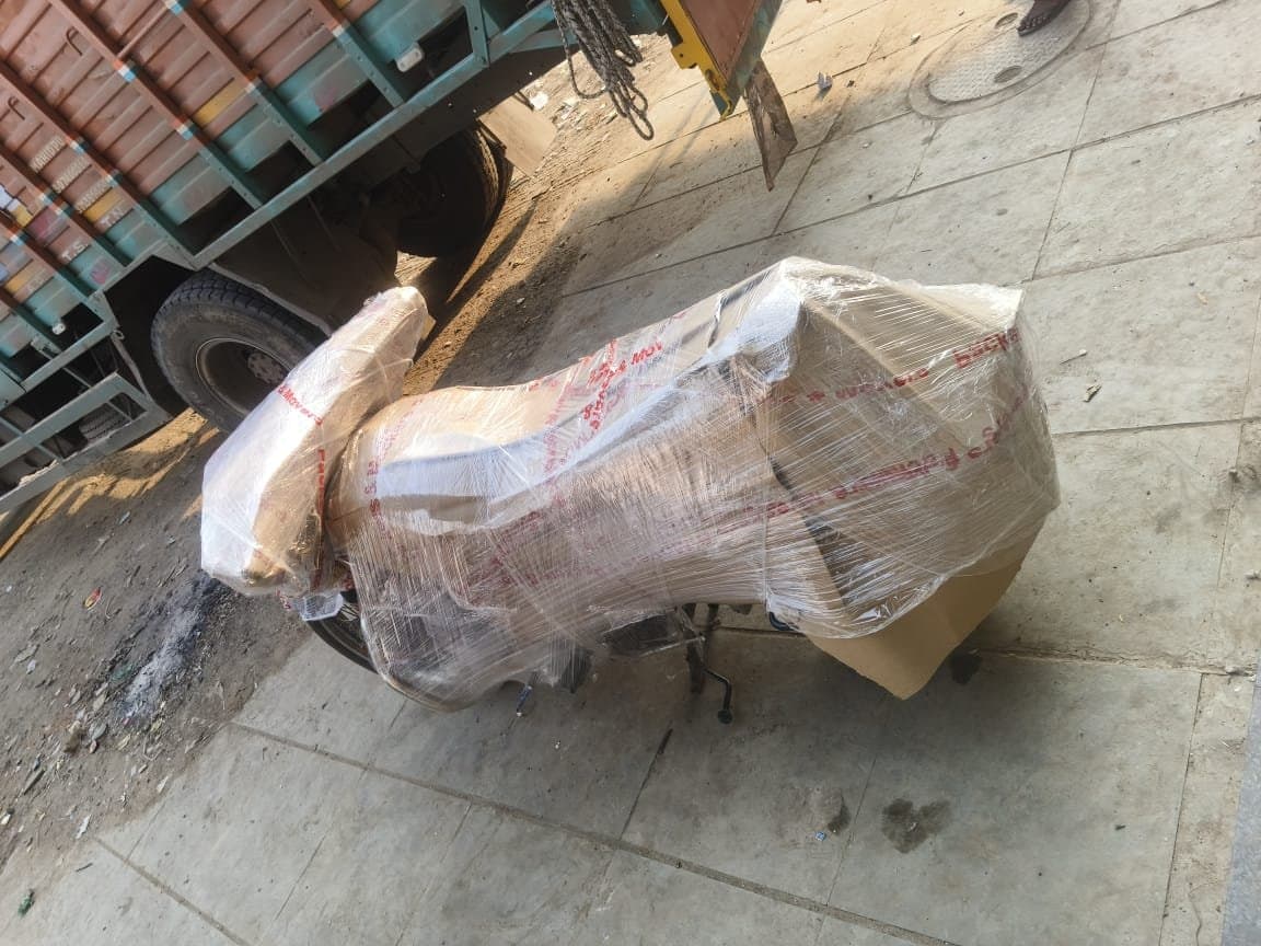 Scooter fully wrapped and padded on the ground next to a truck