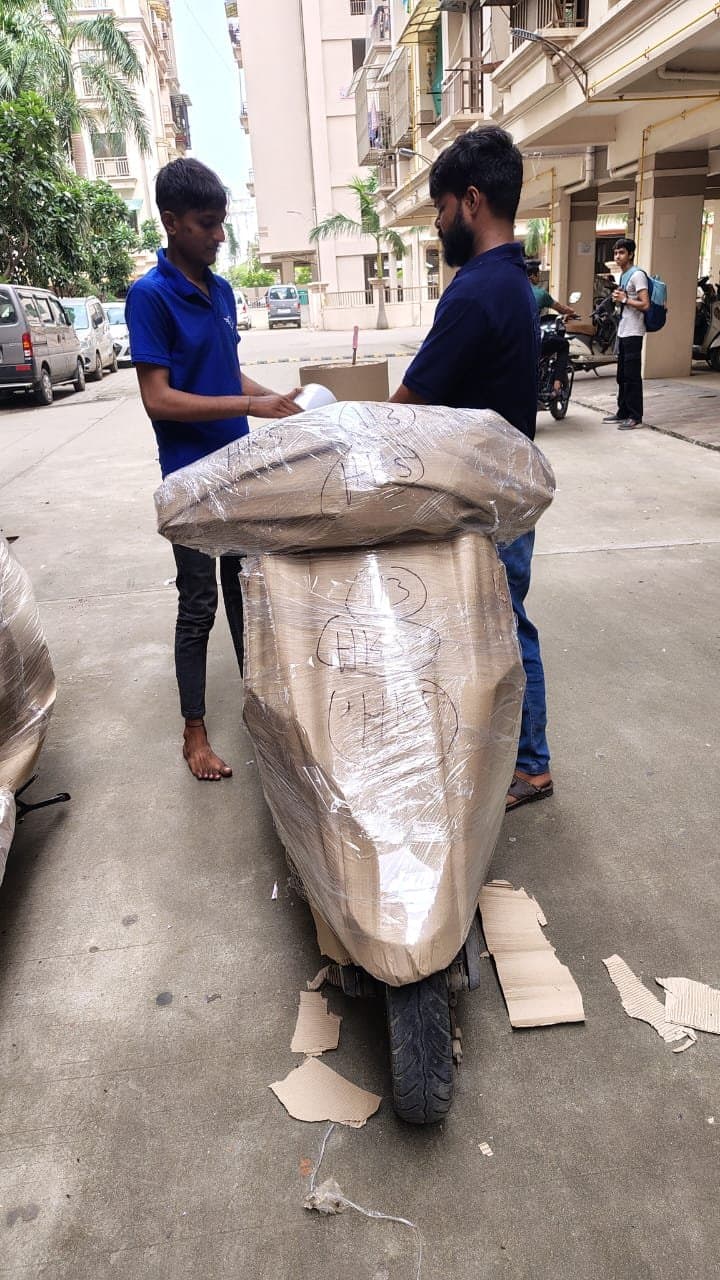 Two HKS Cargo workers wrapping a scooter for transport