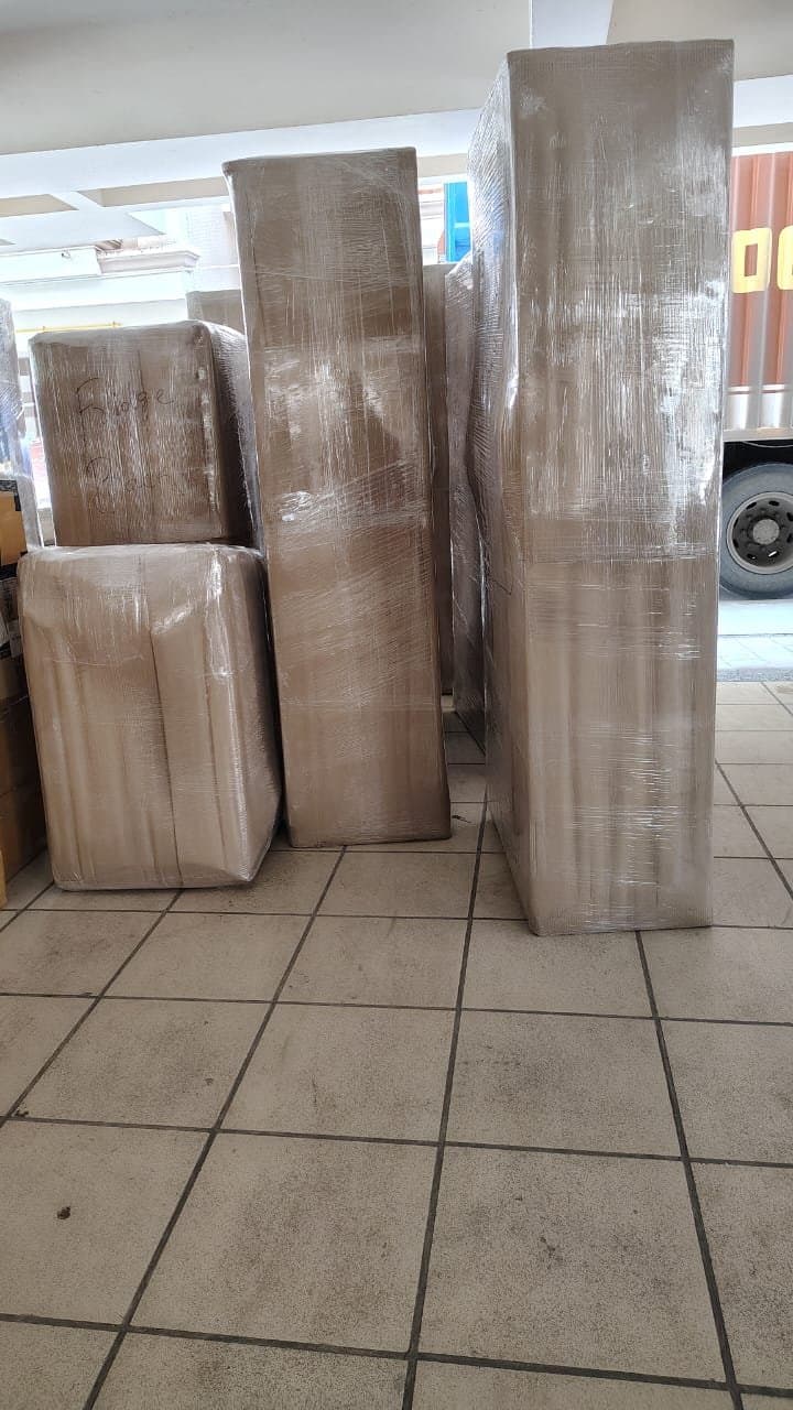 Furniture pieces wrapped in stretch film staged for loading