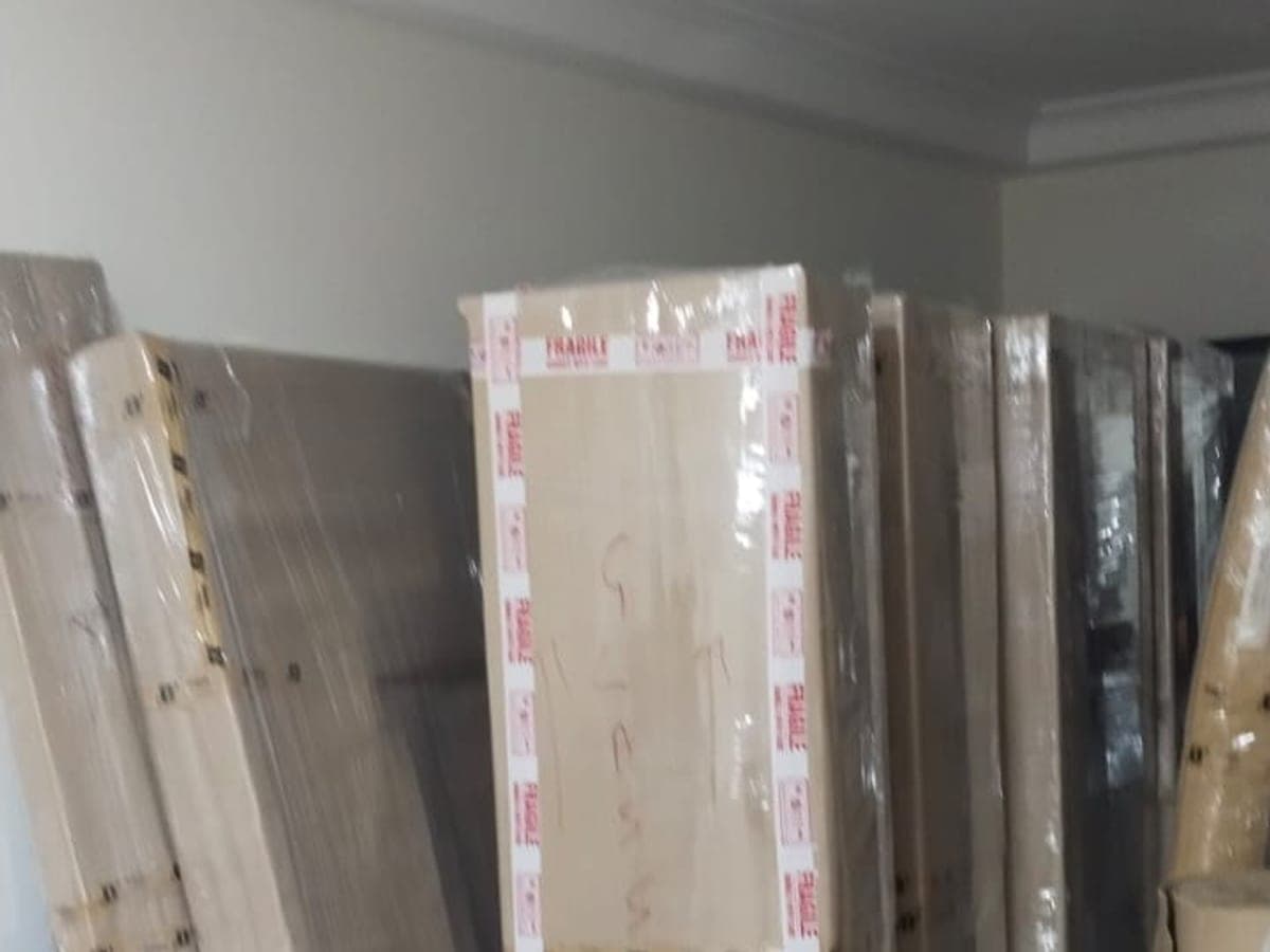 Wrapped furniture panels marked fragile stacked against a wall