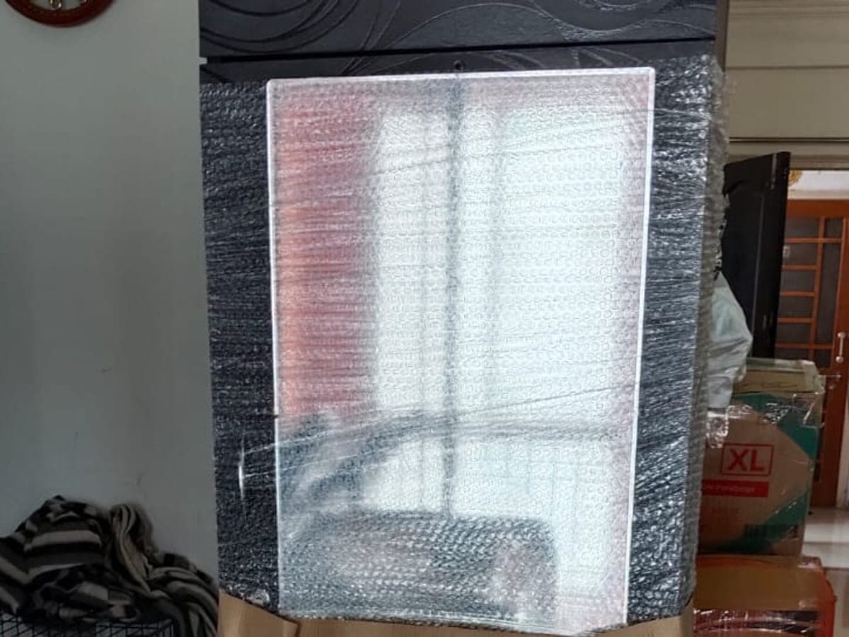 A wardrobe covered in bubble wrap with its mirror panel taped over for protection