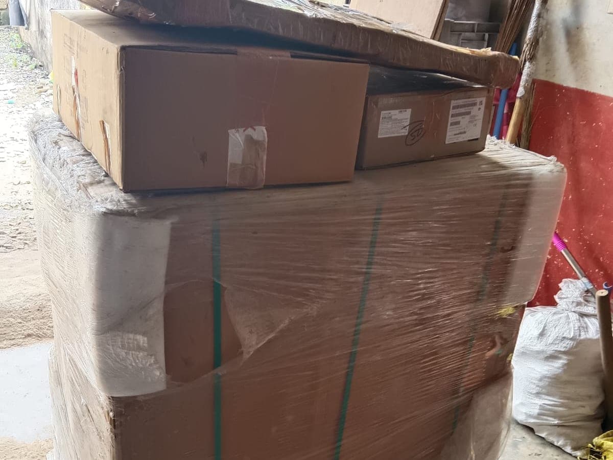 Wrapped and boxed household goods stacked in a garage, staged ahead of loading