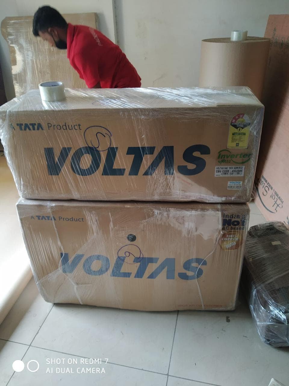 Team member packing Voltas air conditioner boxes with stretch film