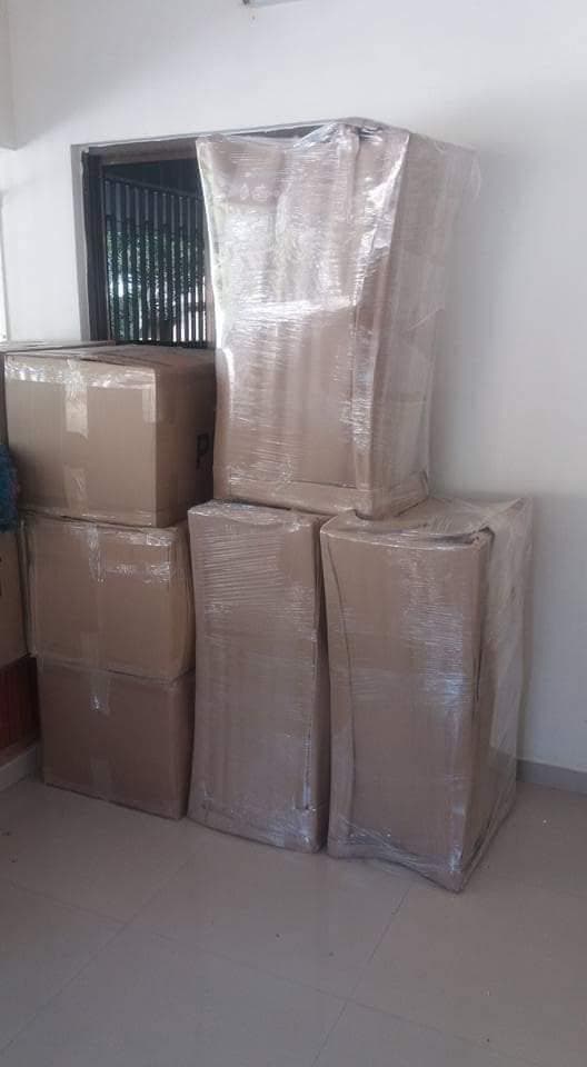 Refrigerator and cartons wrapped and stacked indoors
