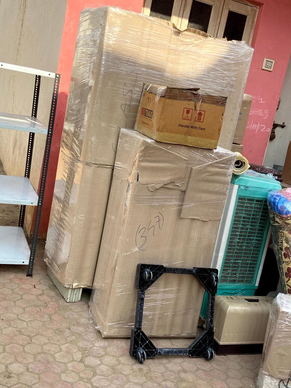 Refrigerator, air cooler and cartons wrapped and staged with a dolly
