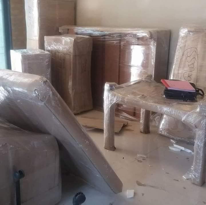 Wrapped furniture and a plastic table labelled glass for careful handling