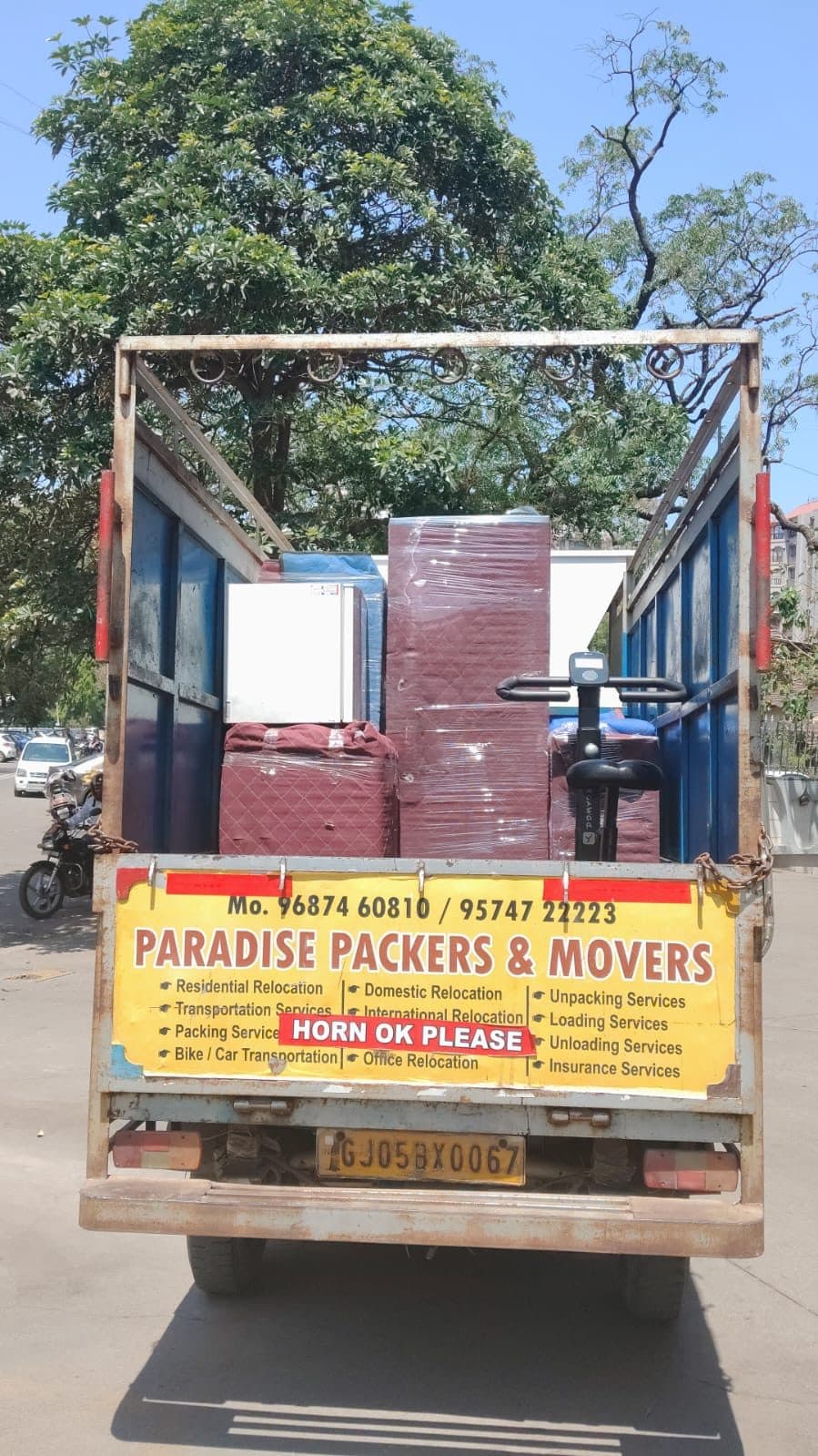 Paradise Packers and Movers branded truck with contact numbers and service list