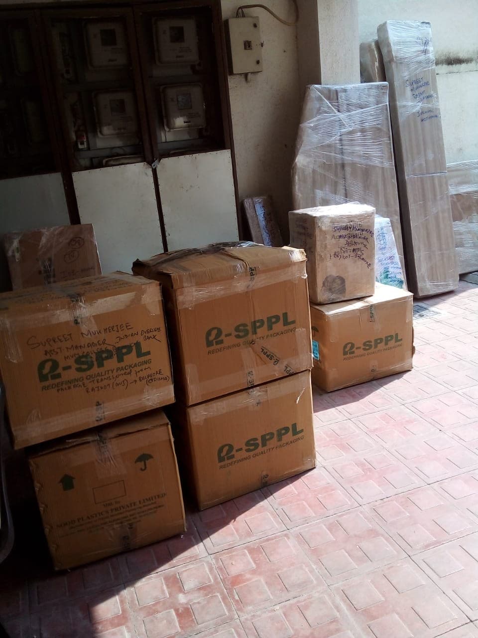 Stacked branded cartons and wrapped mattresses labelled for an interstate move