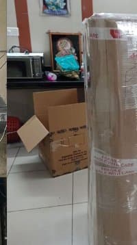 Packed cartons and wrapped items at a customer home before loading