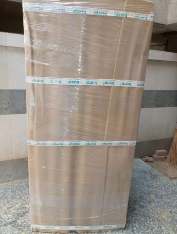 A tall almirah wrapped in cartons and stretch film for shifting