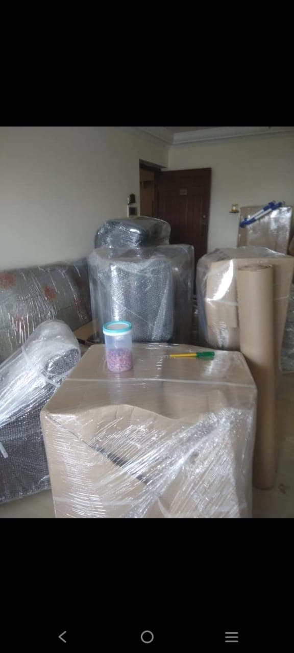 Sofa, cartons and household goods wrapped and staged in a living room