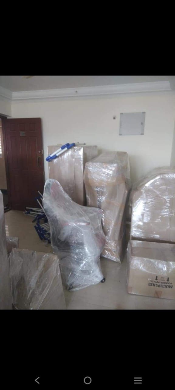 Wrapped furniture and boxes staged near the door ready for loading