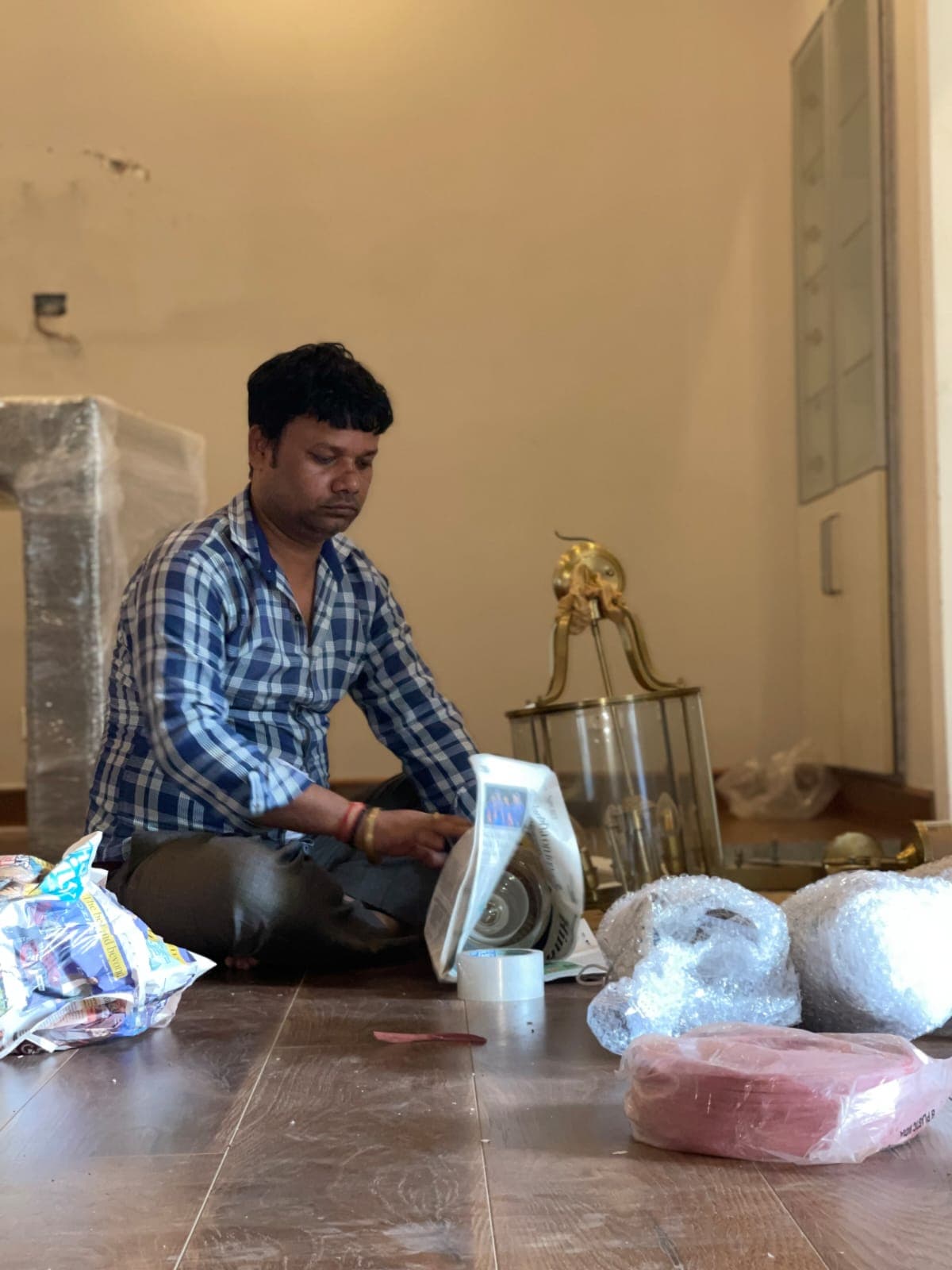 A mover wrapping household decor with bubble wrap